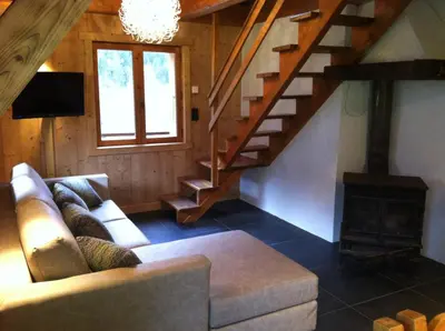 a living room with a couch and a staircase at Chalet Narcisse in Sixt