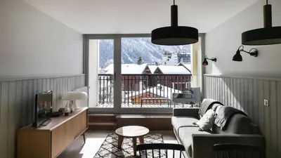 a living room with a couch and a balcony at Appartement La Vallée Blanche avec parking gratuit in Chamonix-Mont-Blanc
