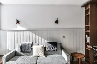 a living room with a gray couch and two lights at Appartement La Vallée Blanche avec parking gratuit in Chamonix-Mont-Blanc