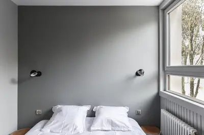 a bedroom with a bed with white sheets and a window at Appartement La Vallée Blanche avec parking gratuit in Chamonix-Mont-Blanc