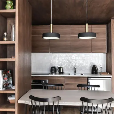 a kitchen with wooden cabinets and a table with chairs at Appartement La Vallée Blanche avec parking gratuit in Chamonix-Mont-Blanc