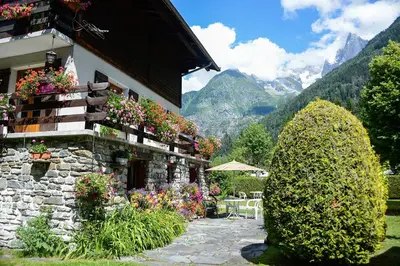 a building with flowers on the side of it at Crêmerie Balmat in Chamonix-Mont-Blanc