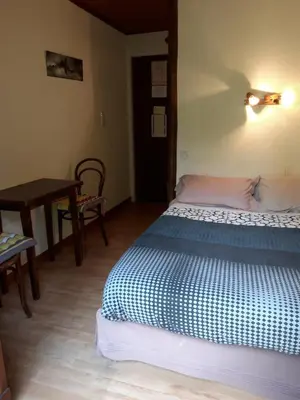 a bedroom with a bed and a table and a table at Crêmerie Balmat in Chamonix-Mont-Blanc