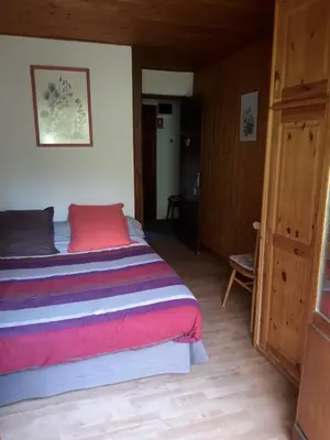 a bedroom with a bed and a wooden floor at Crêmerie Balmat in Chamonix-Mont-Blanc