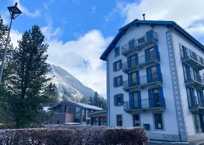 a white building with balconies and a mountain at Apartment Maya, La Praz, Chamonix Mont Blanc in Chamonix-Mont-Blanc