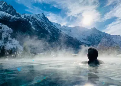 a person in a hot tub in the mountains at Apartment Maya, La Praz, Chamonix Mont Blanc in Chamonix-Mont-Blanc