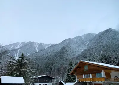 a ski lodge with snow on the mountains in the background at Apartment Maya, La Praz, Chamonix Mont Blanc in Chamonix-Mont-Blanc