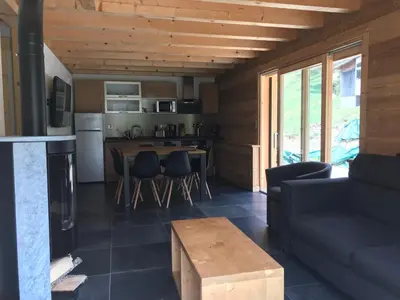 a kitchen and living room with a couch and a table at Chalet La R'Batte in Sixt