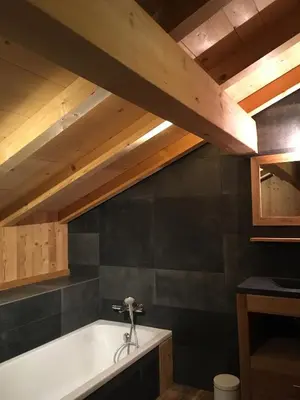 a bath tub in a room with a wooden ceiling at Chalet La R'Batte in Sixt