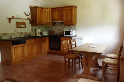 a kitchen with wooden cabinets and a table with chairs at Chalet La R'Batte in Sixt