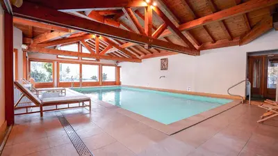 a swimming pool with a bench and a chair in a house at Hôtel des 2 Gares in Saint-Gervais-les-Bains