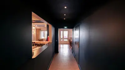 a hallway of a bathroom with a sink and a mirror at Hôtel des 2 Gares in Saint-Gervais-les-Bains