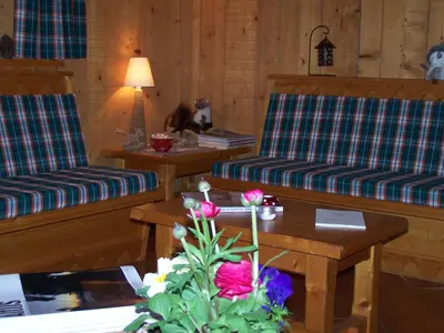 a living room with two couches and a table with flowers at le Montagny in Les Houches