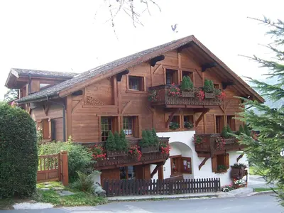a large wooden house with flower boxes on it at le Montagny in Les Houches
