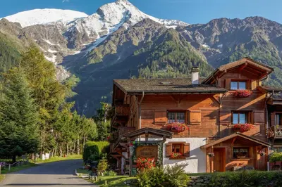 a house on a road with mountains in the background at le Montagny in Les Houches