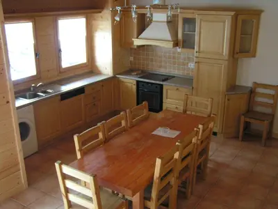 a kitchen with a wooden table and chairs at Chalet des Cascades in Sixt