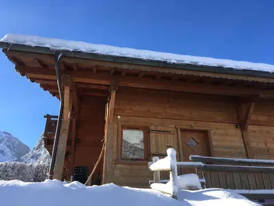 a log cabin with snow on the roof at Chalet des Cascades in Sixt