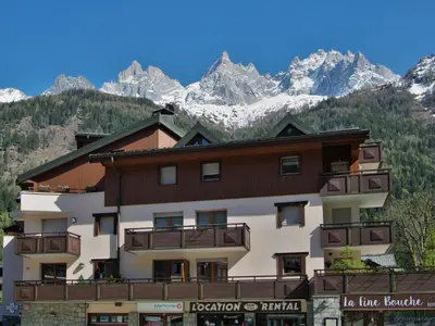 a large building with mountains in the background at Apartment L'Espace Montagne-5 by Interhome in Chamonix-Mont-Blanc
