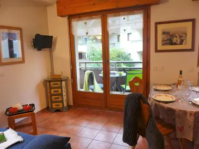 a living room with a table and a sliding glass door at Apartment L'Espace Montagne-5 by Interhome in Chamonix-Mont-Blanc