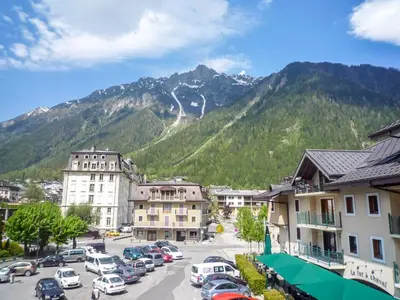 a town with cars parked in a parking lot in front of a mountain at Apartment L'Espace Montagne-8 by Interhome in Chamonix-Mont-Blanc