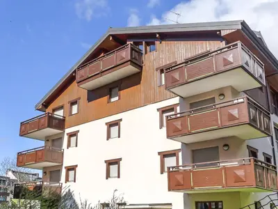 a large building with mountains in the background at Apartment L'Espace Montagne-8 by Interhome in Chamonix-Mont-Blanc