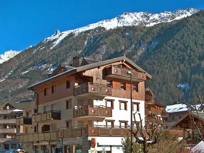a kitchen with a table with chairs and a kitchen with a tableablish at Apartment L'Espace Montagne-8 by Interhome in Chamonix-Mont-Blanc