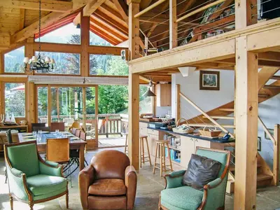 a living room with a fireplace and a table and chairs at Chalet L'Epachat by Interhome in Mémontel