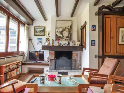 a living room with a fireplace and a tv at Apartment Le Bois du Bouchet-1 by Interhome in Chamonix-Mont-Blanc