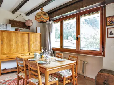 a dining room with a wooden table and chairs at Apartment Le Bois du Bouchet-1 by Interhome in Chamonix-Mont-Blanc