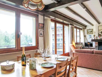 a dining room with a table and some windows at Apartment Le Bois du Bouchet-1 by Interhome in Chamonix-Mont-Blanc