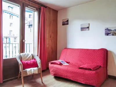 a living room with a red couch and a chair at Apartment l'Armancette by Interhome in Chamonix-Mont-Blanc