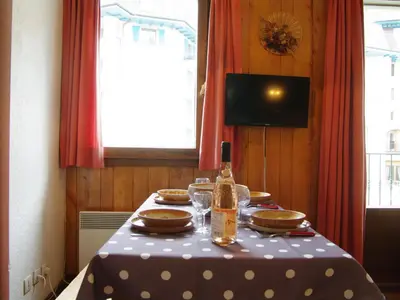 a table with a bottle of wine and glasses on it at Apartment l'Armancette by Interhome in Chamonix-Mont-Blanc