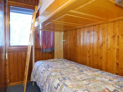 a bedroom with a bed in a wooden room at Apartment Les Charmoz-3 by Interhome in Chamonix-Mont-Blanc