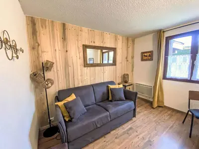 a living room with a couch and a window at Apartment Le Choucas by Interhome in Chamonix-Mont-Blanc