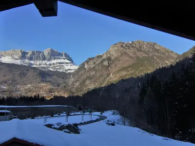 a view of a snow covered mountain range with a river at Chalet Pierre Blanche by Interhome in Servoz