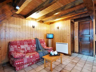 a living room with a couch and a tv at Chalet Pierre Blanche by Interhome in Servoz