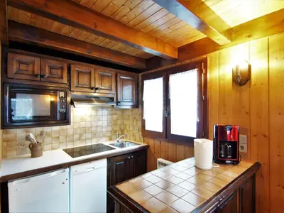 a kitchen with wooden cabinets and a counter top at Chalet Pierre Blanche by Interhome in Servoz