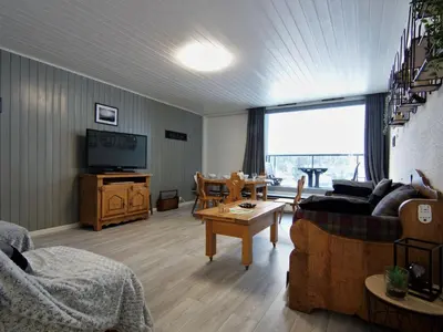a dining room with a table and chairs and a tv at Apartment L'Outa by Interhome in Chamonix-Mont-Blanc