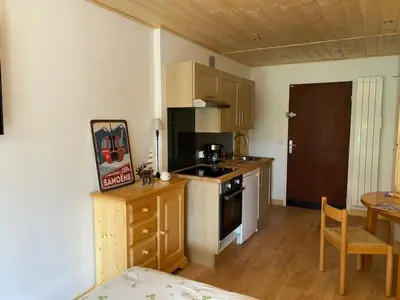 a kitchen with a counter and a table and a kitchen with a stove at Multi résidences Samoëns in Samoëns