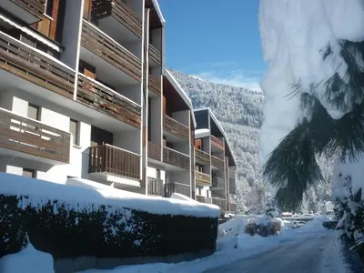 a snow covered street in front of a building at Multi résidences Samoëns in Samoëns