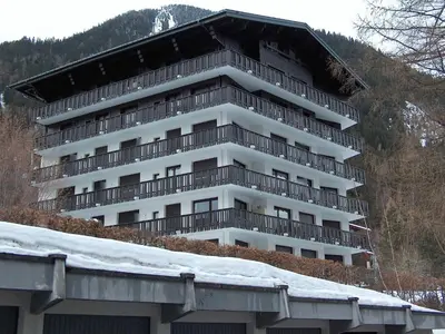 a snow covered street with a building and a stop sign at Apartment Les Aiguilles du Brévent by Interhome in Chamonix-Mont-Blanc