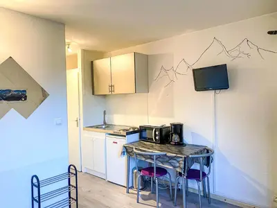 a small kitchen with a table with a microwave at Studio Arve 1 et 2-3 by Interhome in Chamonix-Mont-Blanc
