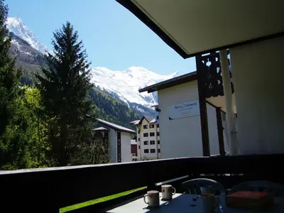 a balcony with a table with a view of a mountain at Studio Le Grépon-3 by Interhome in Chamonix-Mont-Blanc