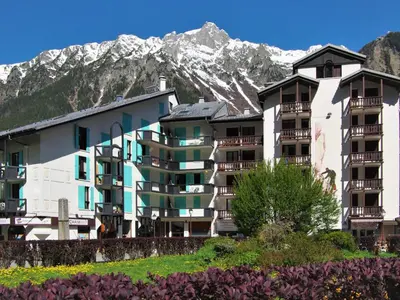 a large apartment building with mountains in the background at Apartment La Forclaz-2 by Interhome in Chamonix-Mont-Blanc