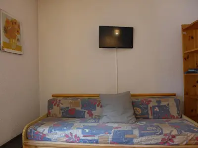 a living room with a couch and a television on the wall at Apartment La Forclaz-2 by Interhome in Chamonix-Mont-Blanc