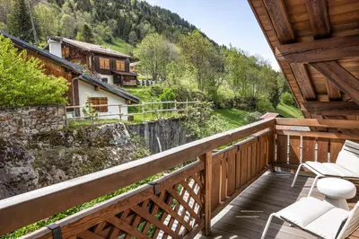 a bedroom with a bed and two chairs at Armancette - The Leading Hotels of the World in Saint-Gervais-les-Bains