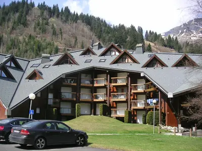 a large building with cars parked in front of it at Apartment Pierres Blanches F et H-20 by Interhome in Le Cugnon