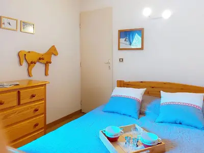 a bedroom with a bed with a tray of food on it at Apartment Pierres Blanches F et H-20 by Interhome in Le Cugnon