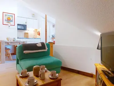 a small bedroom with a bed with a blue comforter at Apartment Pierres Blanches F et H-20 by Interhome in Le Cugnon