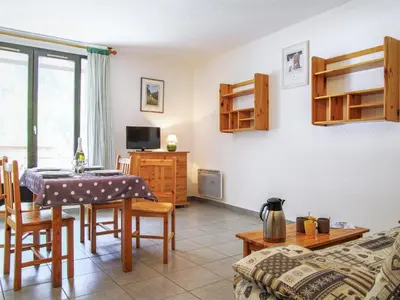 a living room with a table and a bedroom at Apartment Gentiane-3 by Interhome in Chamonix-Mont-Blanc
